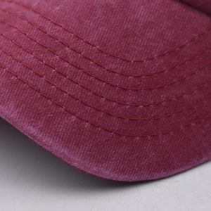 Vue macro du bord d'une casquette en coton bordeaux avec détails de coutures renforcées