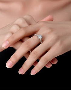 Detailed shot of S925 silver engagement ring featuring a round moissanite with pavé band