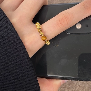 Detail view of 18K gold plated beaded tiger eye stone ring worn on finger with natural texture