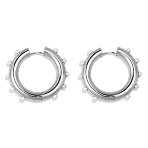 Detail view of silver hoop earrings decorated with small white pearls on a white background