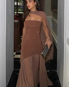 Detail of elegant brown strapless evening dress with one-shoulder cape and high slit