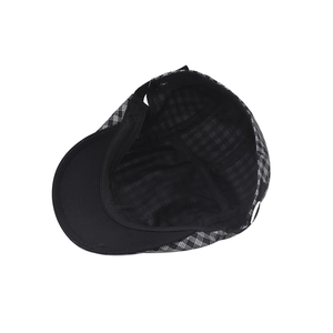 Detail view of the vintage plaid flat cap featuring black inner lining and peak brim