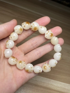 Macro shot of white jade cat paw beads with brown details on an ethnic-style bracelet
