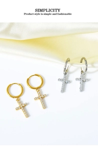 Macro detail of gold and silver cross hoop earrings with inlaid cubic zirconia crystals