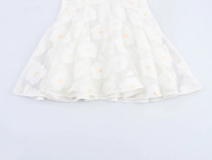 Close-up of white floral embroidery on tiered mesh puff sleeve dress skirt