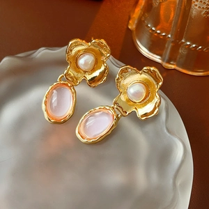 Macro detail of vintage floral earrings with pink stones and pearls on glass