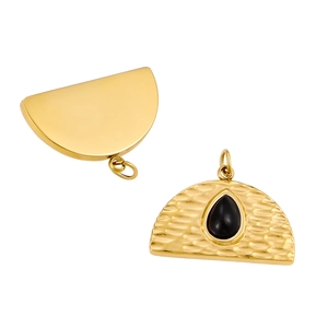 Detail of gold semicircular pendant with hammered texture and black teardrop gemstone