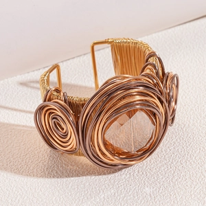Detail of handcrafted wire-wrapped open bangle with a large faceted crystal stone
