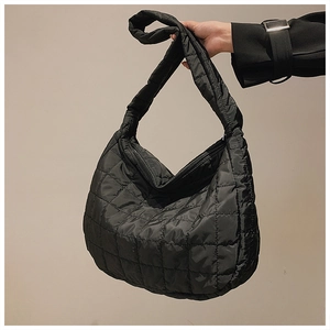 Detail of black quilted puffer shoulder bag showing texture and lattice stitching