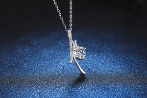 Close-up of S925 sterling silver bow necklace with a round 1-carat moissanite pendant