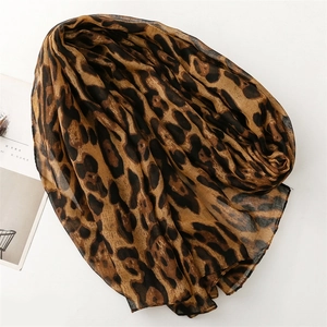 Flat lay detail of a lightweight cotton-linen scarf with a large leopard animal print