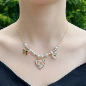 Handmade pearl necklace with 18K gold heart and bow pendants on a model neck