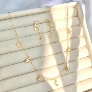 Elegant gold star and moon jewelry set with necklace and earrings in a gift box