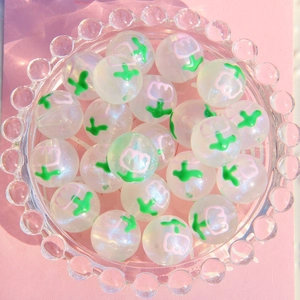 Gros plan de perles étoilées de 16mm avec tulipes et paillettes dans un bol en verre