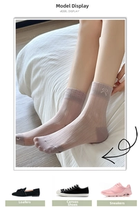 Detail of light purple crew socks featuring white bow embroidery and vertical knit texture