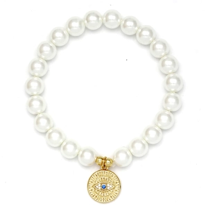 Close-up of pearl beaded bracelet with a golden evil eye charm and blue gemstone inlay