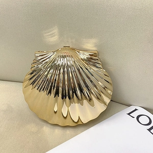 Detailed view of golden metallic shell-shaped clutch with textured finish and metal clasp