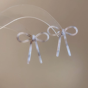 Vue macro des boucles d'oreilles nœud en acétate avec texture marbrée sur un support