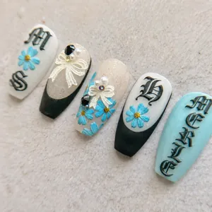Macro detail of 5D embossed nail stickers featuring blue floral and lace butterfly designs