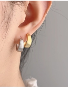 Detail view of S925 sterling silver minimalist hoop earrings worn on a model ear