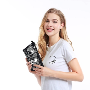 Smiling model holding a waterproof skull and rose pattern vanity bag with white background