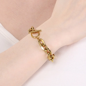 Detailed view of a gold chunky Cuban chain bracelet with a stylish OT toggle clasp