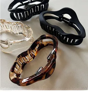 Detailed view of four irregular hair claws in black, matte, clear, and tortoiseshell