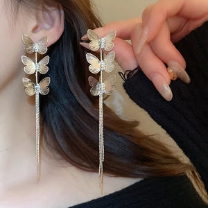 Detail of silver long butterfly tassel earrings with sparkling cubic zirconia on model