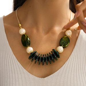 Detail of vintage layered acrylic oval necklace with emerald green and pearl beads on model