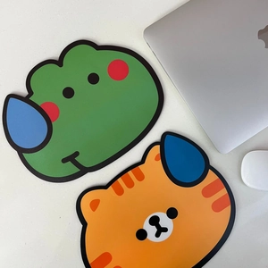 Cartoon animal mouse pads featuring a green frog and orange tiger on a marble desk