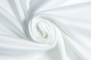 Close-up of white dress fabric showing fine textured grid pattern and soft drape