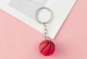 Close-up of pink 3D basketball keychain with textured grooves and silver metal ring