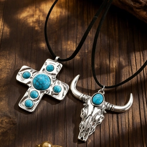 Vintage silver cross and bull skull pendant necklaces with turquoise on rustic wood