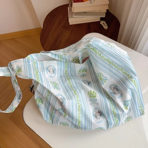 Detail of blue and white striped cotton tote bag with artistic girl and flower illustration
