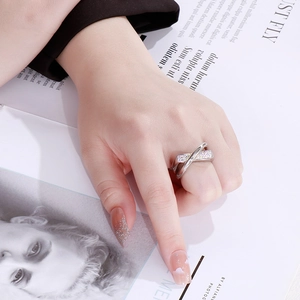Close-up of a silver crossover woven ring featuring sparkling crystal micro-inlays