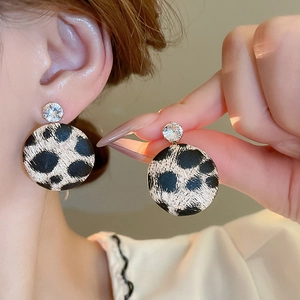 Close-up of leopard print star circle earrings with gold plating and sparkling zircon