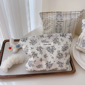 Detail of floral cotton makeup bag featuring simple wish label and soft texture