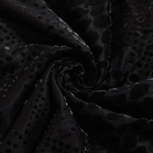 Close-up of black jacquard fabric with 3D polka dot texture and glossy finish