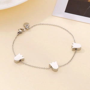 Macro detail of tulip flower bracelet with silver chain and white enamel charms