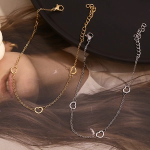 Detailed shot of gold and silver heart link anklet with lobster clasp and adjustable chain