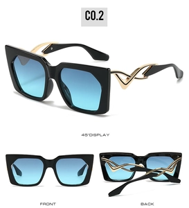 Detail of cat-eye sunglasses with blue gradient lenses and golden wavy temple design