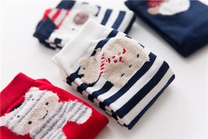 Detail of plush cartoon bear embroidery on soft festive feather yarn striped socks