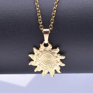 Detailed close-up of golden sun-shaped pendant with spiral design on black leather