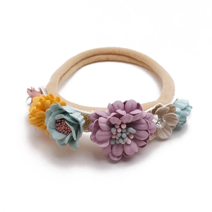 Detail of baby floral headband with elastic nylon band and pastel fabric flowers