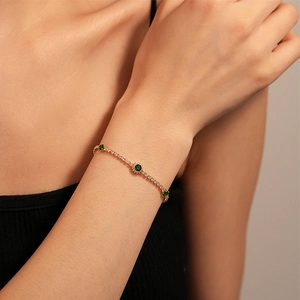 Vintage gold tennis bracelet featuring emerald green round zircons and white stone accents