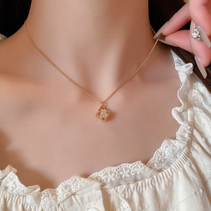 Macro detail of 18k gold plated hollow square pendant necklace with sparkling zircon