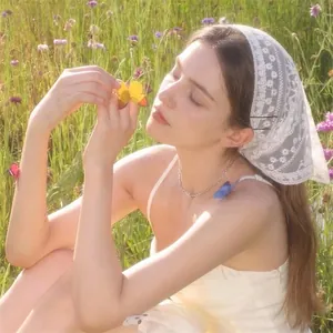 Elegant white floral lace triangle headscarf for women shown in a bright outdoor setting
