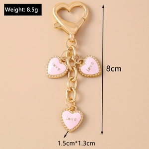 Detailed view of pink heart keychain with love charms and product dimensions