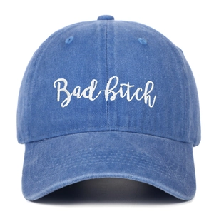 Detail of blue washed cotton baseball cap featuring white Bad Bitch script embroidery
