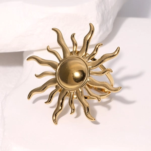 Elegant gold sunburst napkin ring with polished metallic finish on a stone block